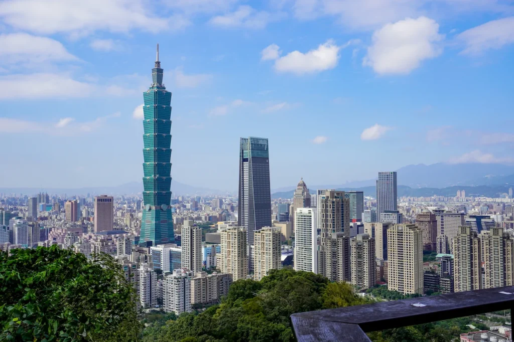 Taipei 101 skyscraper dominating the city skyline under a blue sky with clouds