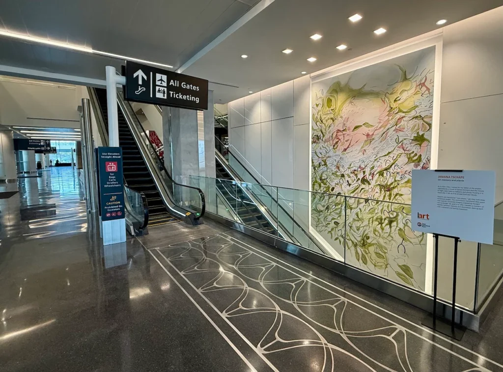 Janaina Tschäpe's colorful mural beside escalators at TPA Airport