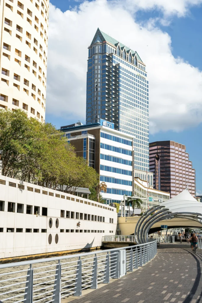 Tampa Riverwalk pedestrian path curves past downtown skyscrapers and the Rivergate Tower in Tampa, Florida