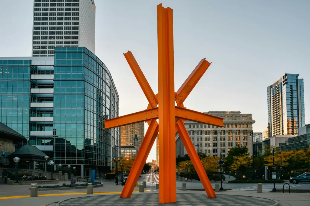 Mark di Suvero's orange steel sculpture standing in a downtown Milwaukee plaza