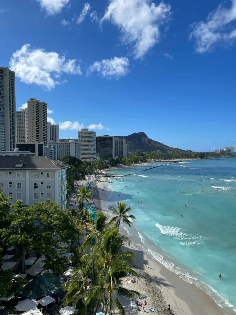 High-angle view of Waikiki Beach hotels, palm trees, and turquoise water leading to Diamond Head crater