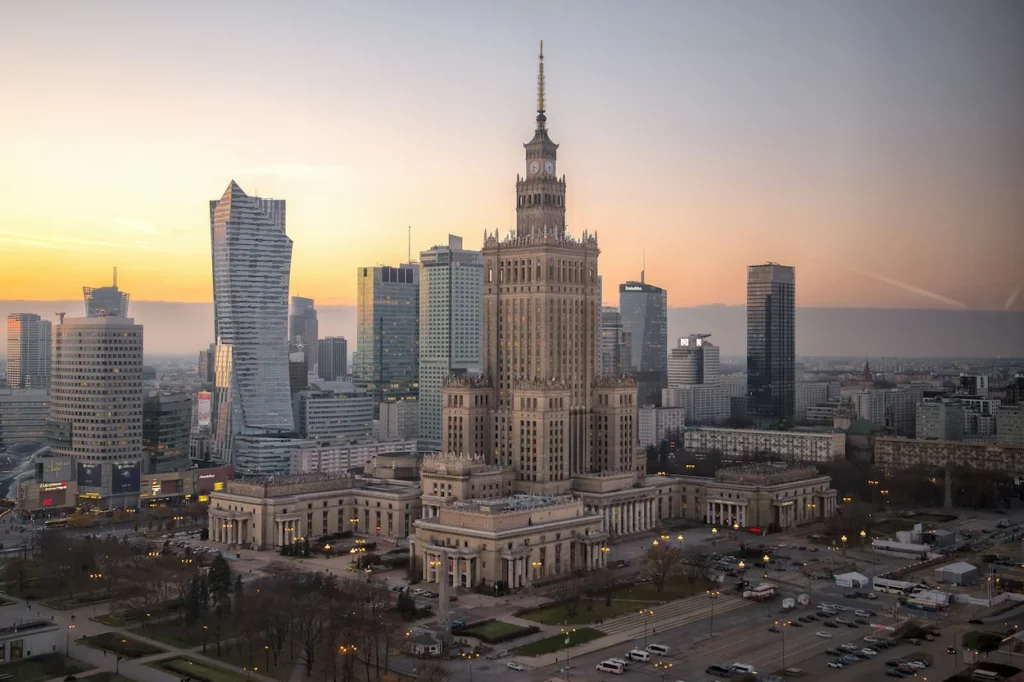 Palace of Culture and Science surrounded by modern skyscrapers in Warsaw at dusk