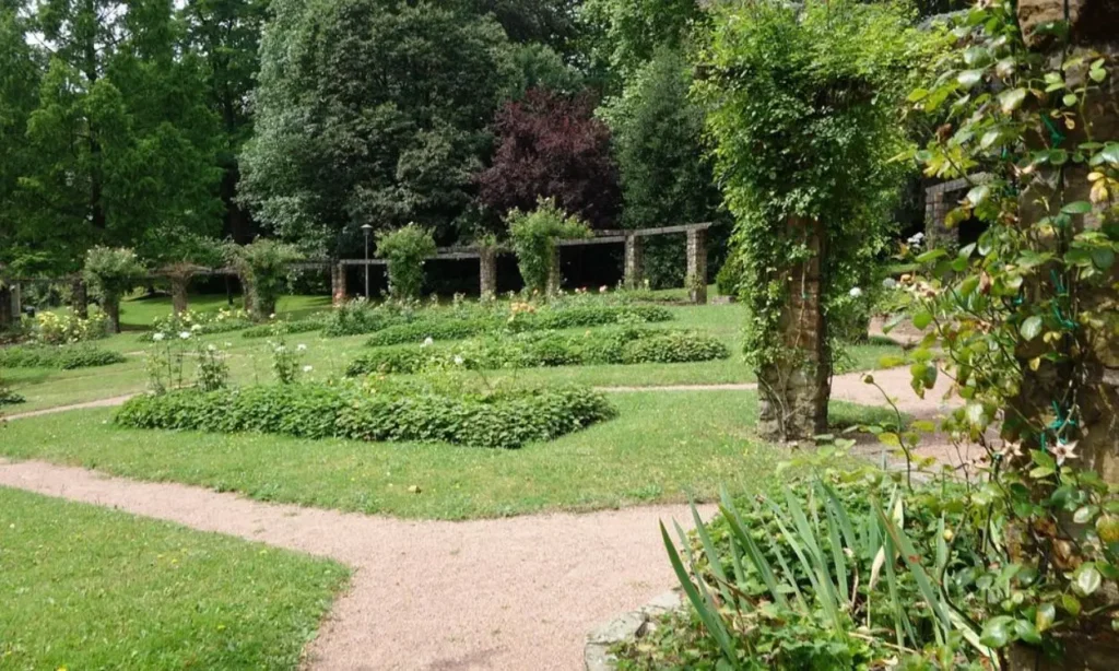 Citadel Park with green lawns, pathways, flower beds, and stone arches.