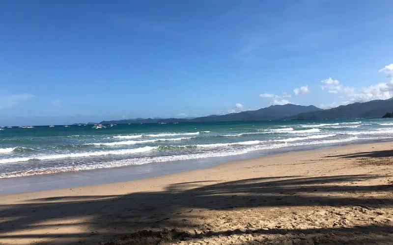 Waves rolling onto the sandy shore at Sabang Beach.