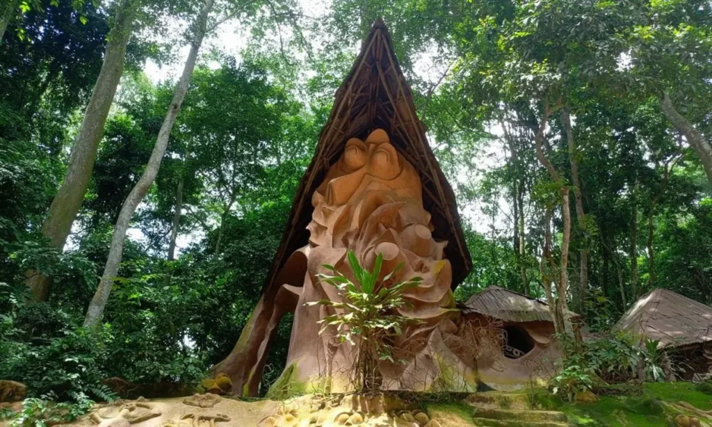 A large sculpted structure surrounded by trees at Osun-Osogbo Sacred Grove.