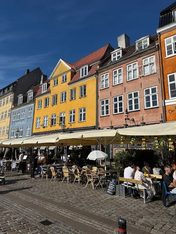 Colorful houses and outdoor cafés along Nyhavn in Copenhagen.