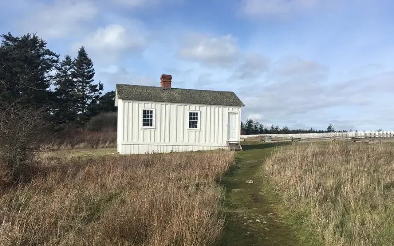 White historic building standing in an open field at San Juan Island National Historical Park.
