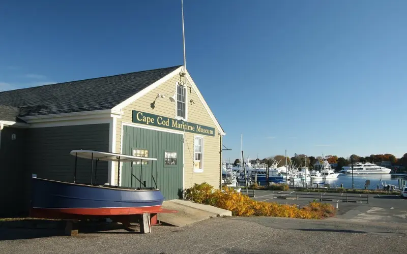 Cape Cod Maritime Museum building with boats in the harbor.