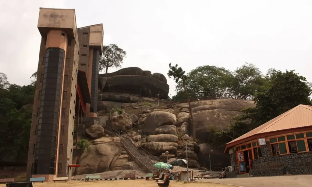 The base of Olumo Rock with its staircase and buildings leading up the rocky hill.