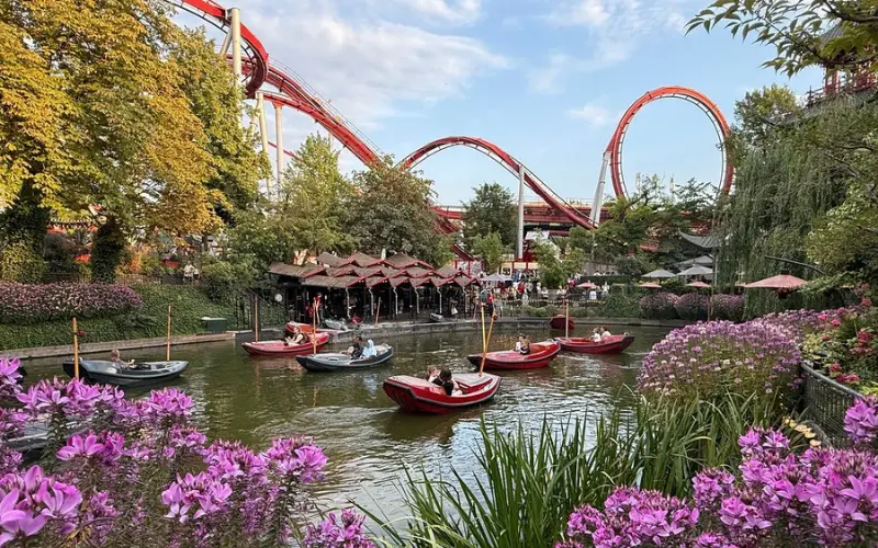 Boats on the lake with rollercoasters in the background at Tivoli Gardens.