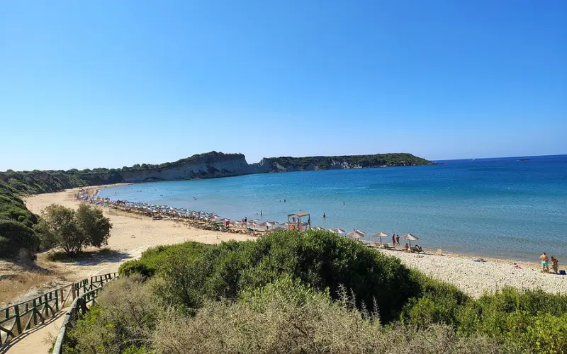 Sandy shoreline with umbrellas and calm water at Gerakas Beach.