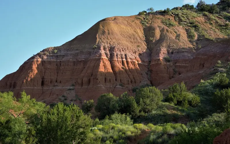 Red rock formations and green vegetation at Palo Duro Canyon.