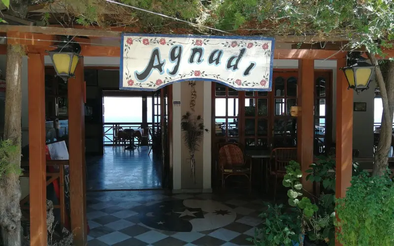 Entrance with a sign and plants at Agnadi Restaurant.
