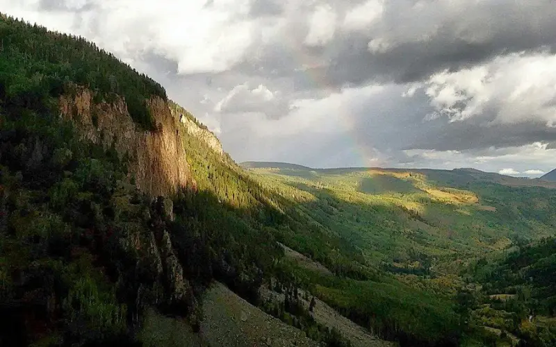 A rainbow stretching across the San Juan Mountains.