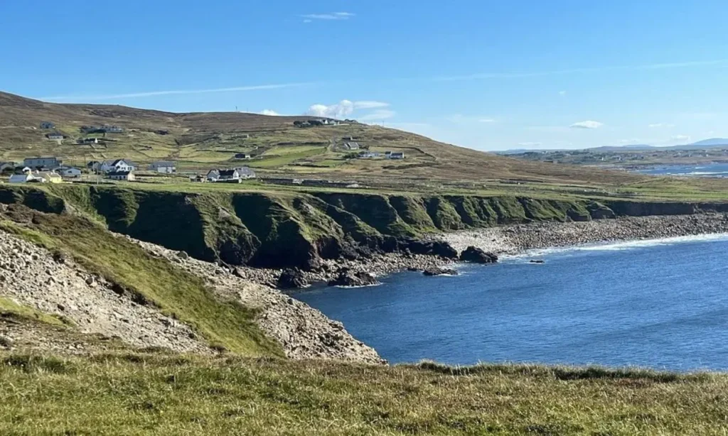 The Wild Atlantic Way shows a rugged coastline with scattered houses and grassy cliffs.