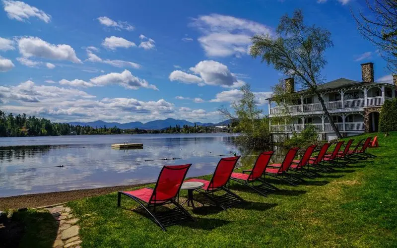 Lakeside view with red lounge chairs at Mirror Lake Inn Resort & Spa.