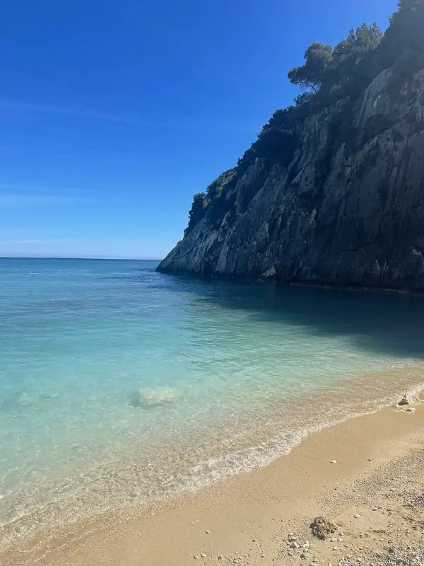 Sandy shore and turquoise water at Xigia Beach.