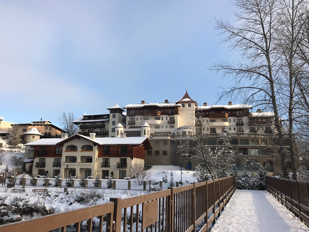 Snowy winter view of Posthotel Leavenworth with chalet-style architecture.