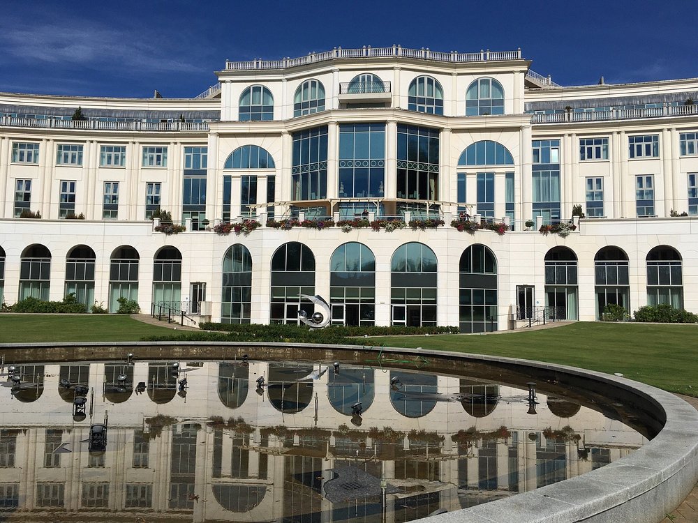Front view of Powerscourt Hotel with grand architecture and reflective pond.