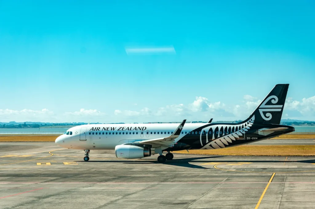 Air New Zealand Airbus A320 plane idling on a sunny airport tarmac