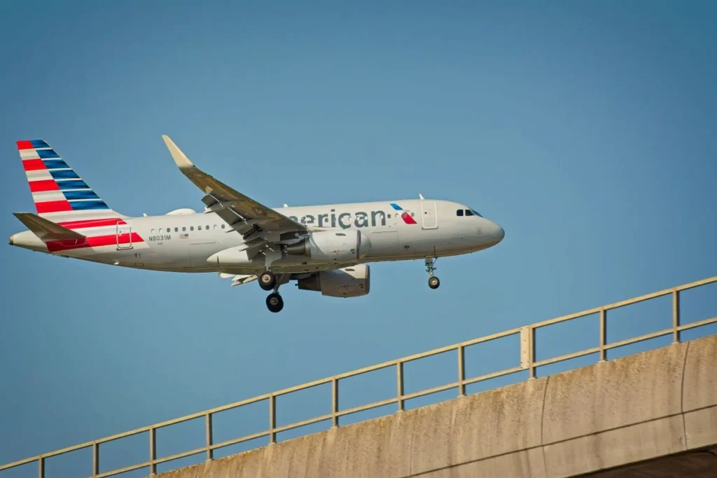An American Airlines Airbus A319 passenger airplane landing on a runway with its landing gear deployed