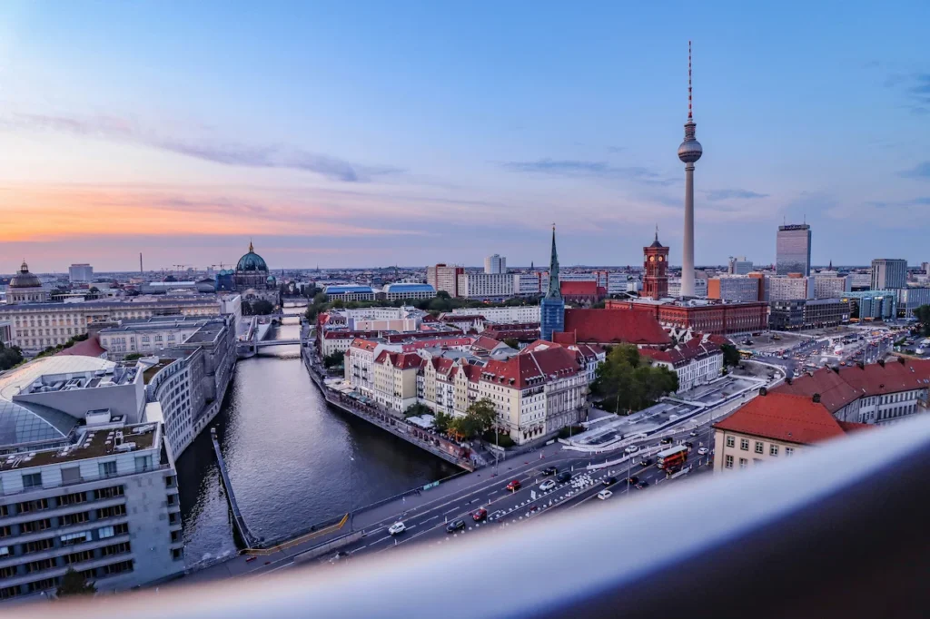High-angle sunset view of Berlin skyline with Fernsehturm TV tower, Spree River, and St. Nicholas Church
