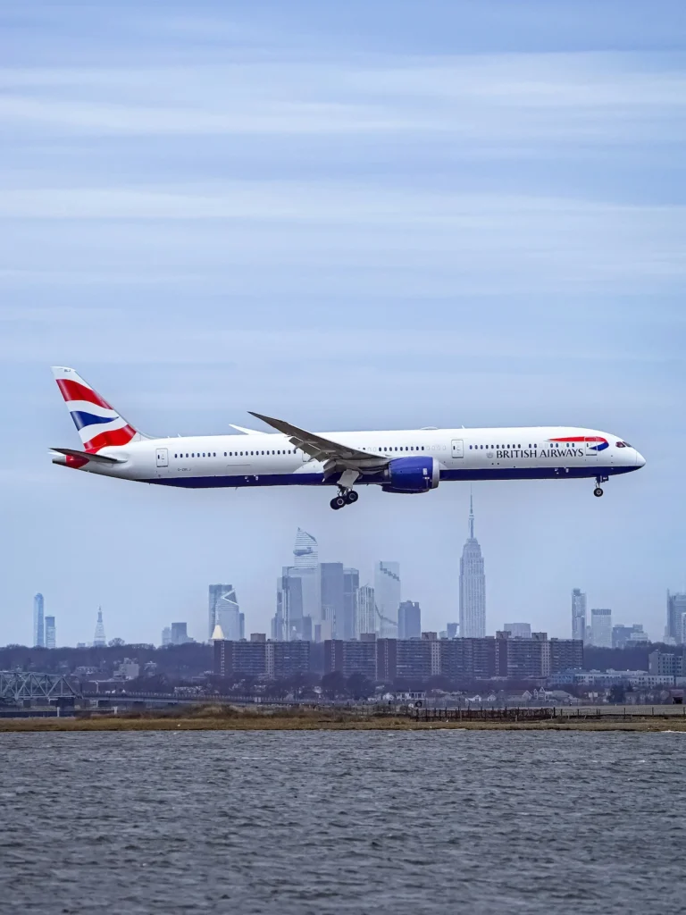 British Airways Boeing 787 plane landing with the NYC skyline behind it