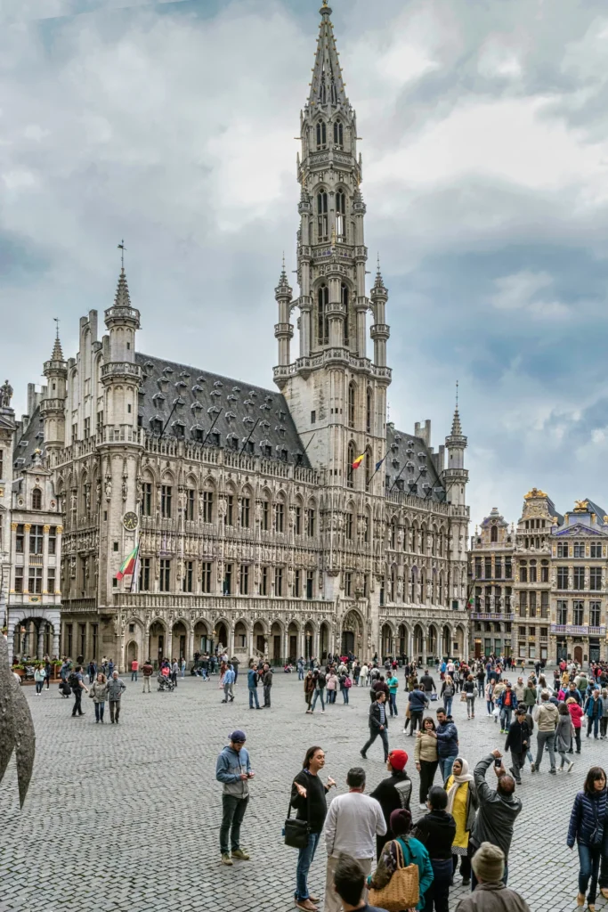 Brussels Town Hall building with its tall central spire towering over crowds at the Grand Place