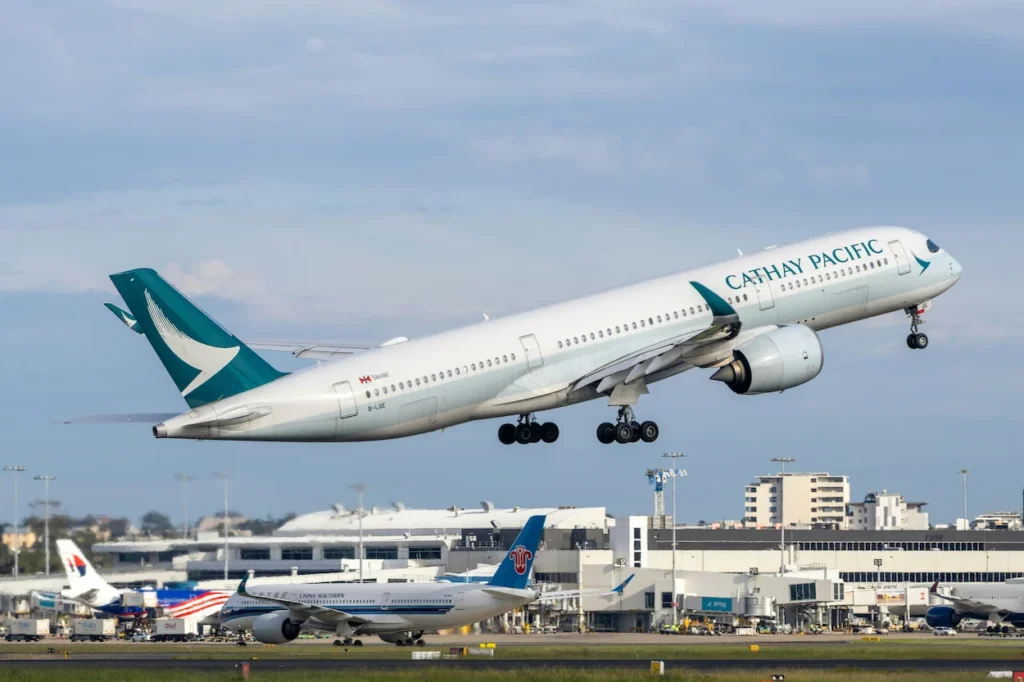 Cathay Pacific Airbus A350-1000 aircraft climbing into the air after taking off above Sydney Airport