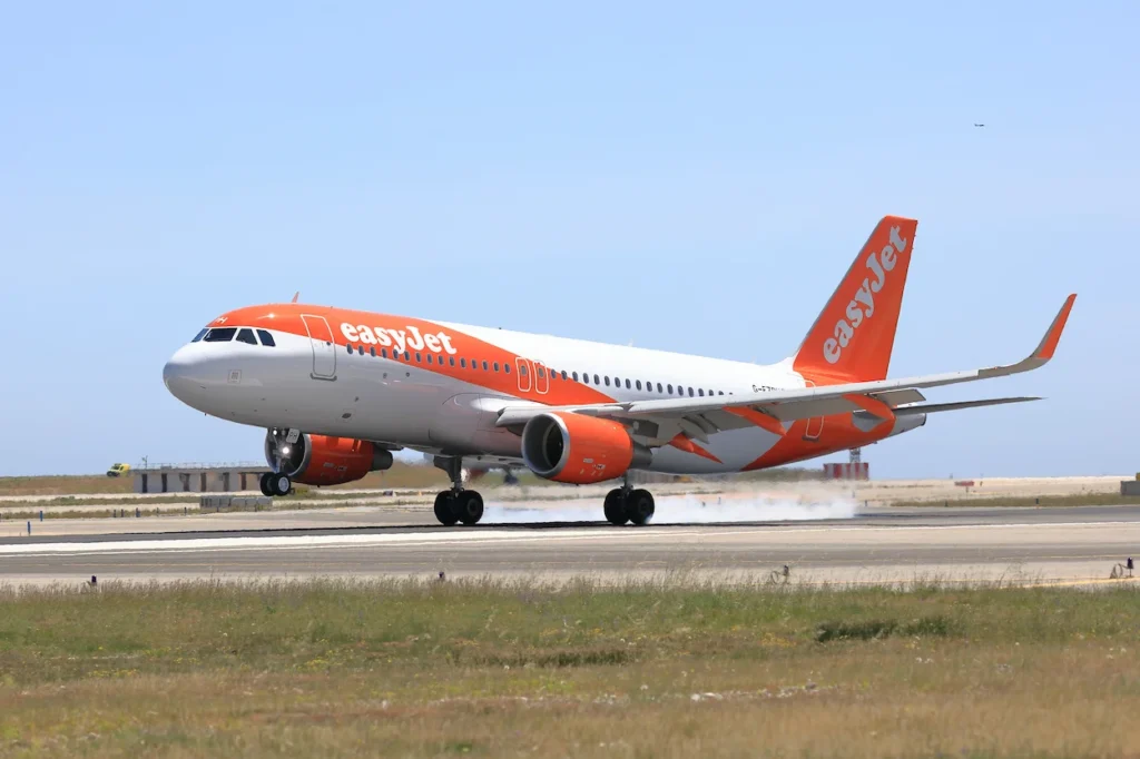 easyJet Airbus A320 commercial airplane landing on an airport runway