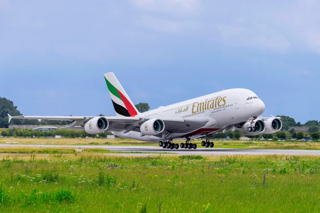 Emirates Airbus A380 double-decker passenger airplane lifting off from a runway