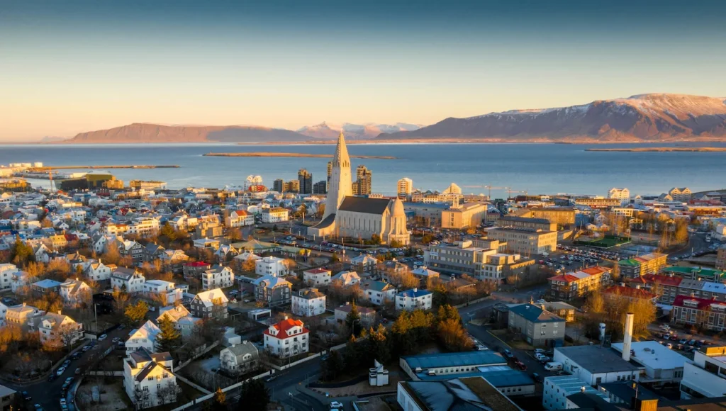 Aerial view of Hallgrimskirkja church and the Reykjavik skyline leading to the ocean and snow-capped mountains
