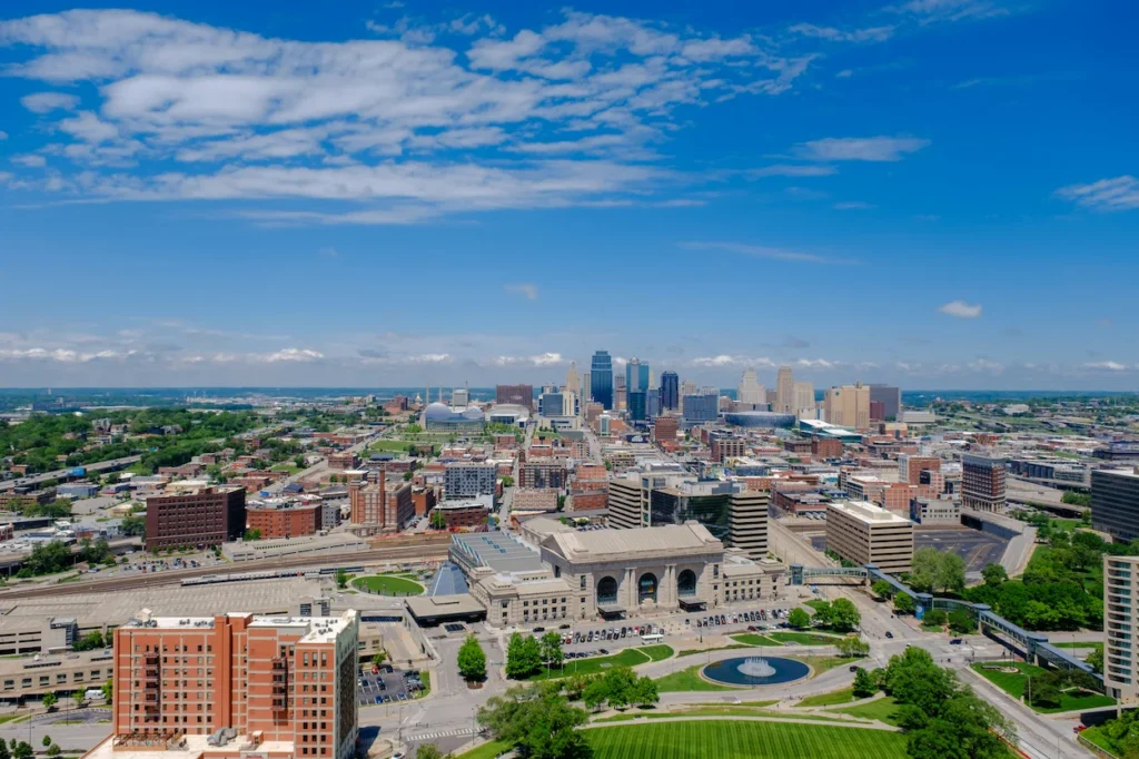 High angle aerial view of the Kansas City skyline stretching behind the historic Union Station building under a blue sky