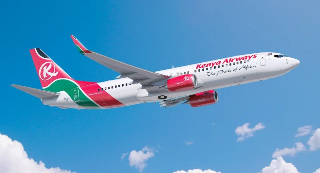 A Kenya Airways Boeing 737 flying through a bright blue sky