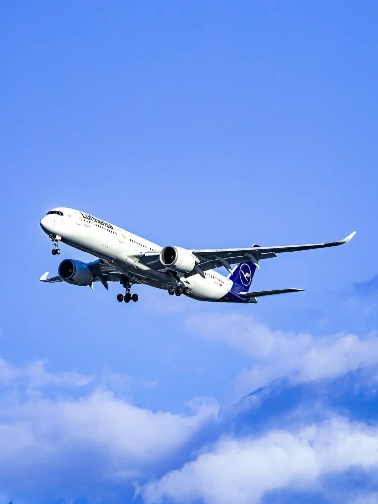 Lufthansa Airbus A350 commercial airplane descending for landing against a bright blue sky