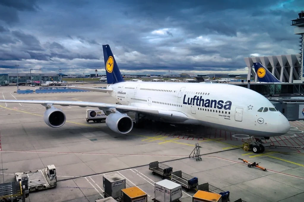 A Lufthansa Airbus A380 parked at a jet bridge terminal gate at Munich Airport