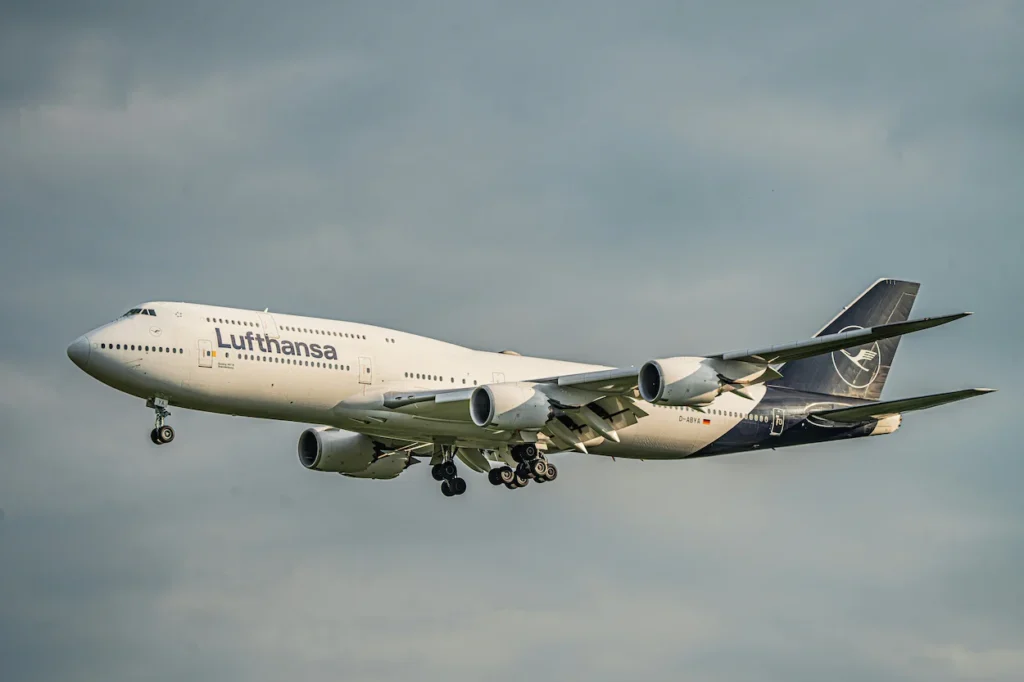 A Lufthansa Boeing 747 airliner landing against a cloudy sky