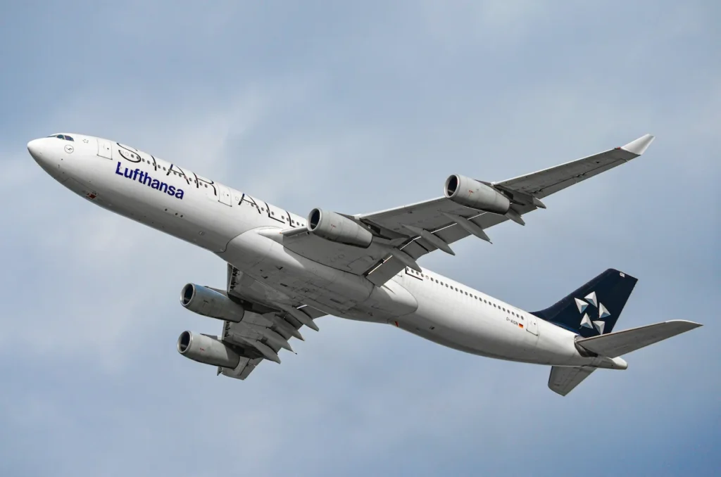 Lufthansa Airbus A340 in Star Alliance livery climbing into a cloudy sky