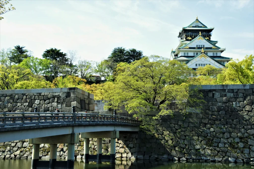 Osaka Castle main keep rising behind the stone walls and Gokurakubashi Bridge