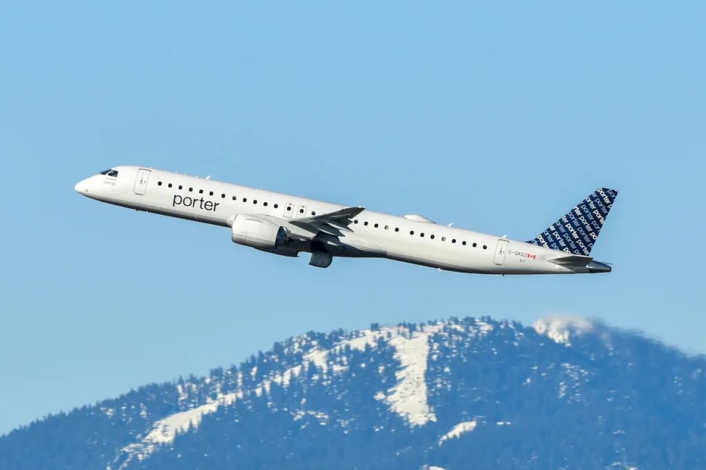 Porter Airlines Embraer E195-E2 passenger jet flying through a clear blue sky