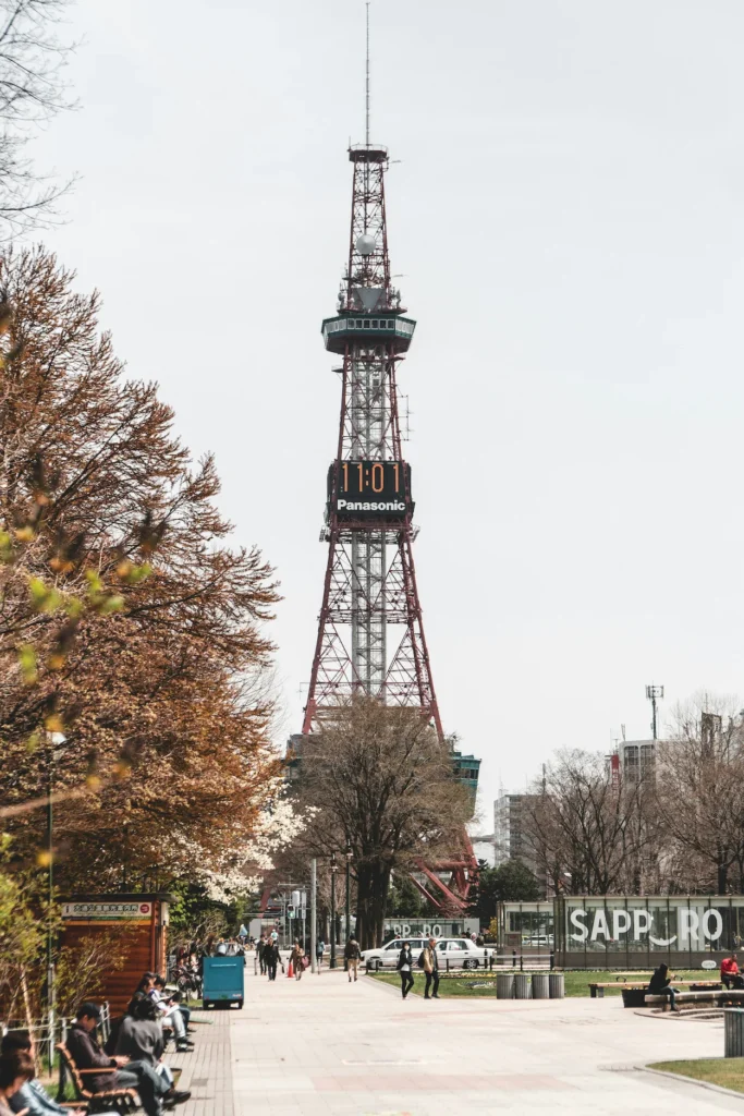 Sapporo TV Tower with a digital clock display viewed from a park path