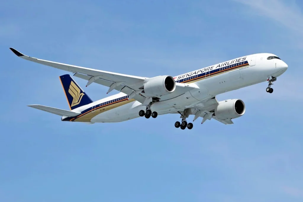 Singapore Airlines Airbus A350 passenger airplane flying high against a clear, deep blue sky