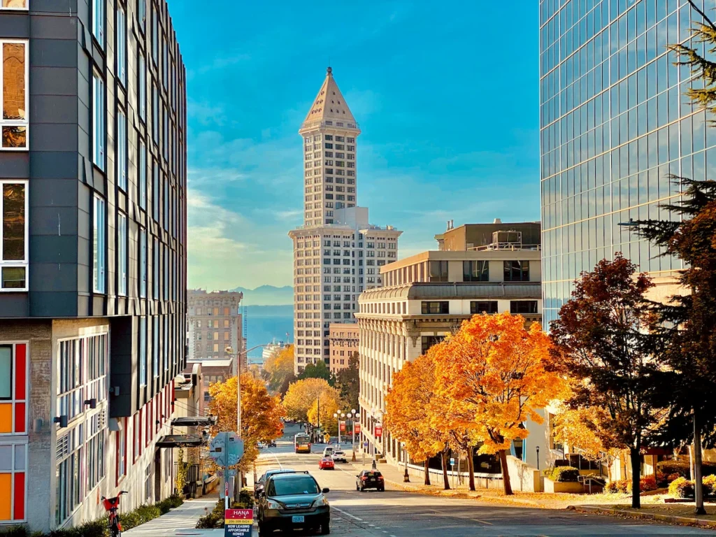 Seattle skyline featuring Smith Tower surrounded by autumn trees under a clear sky