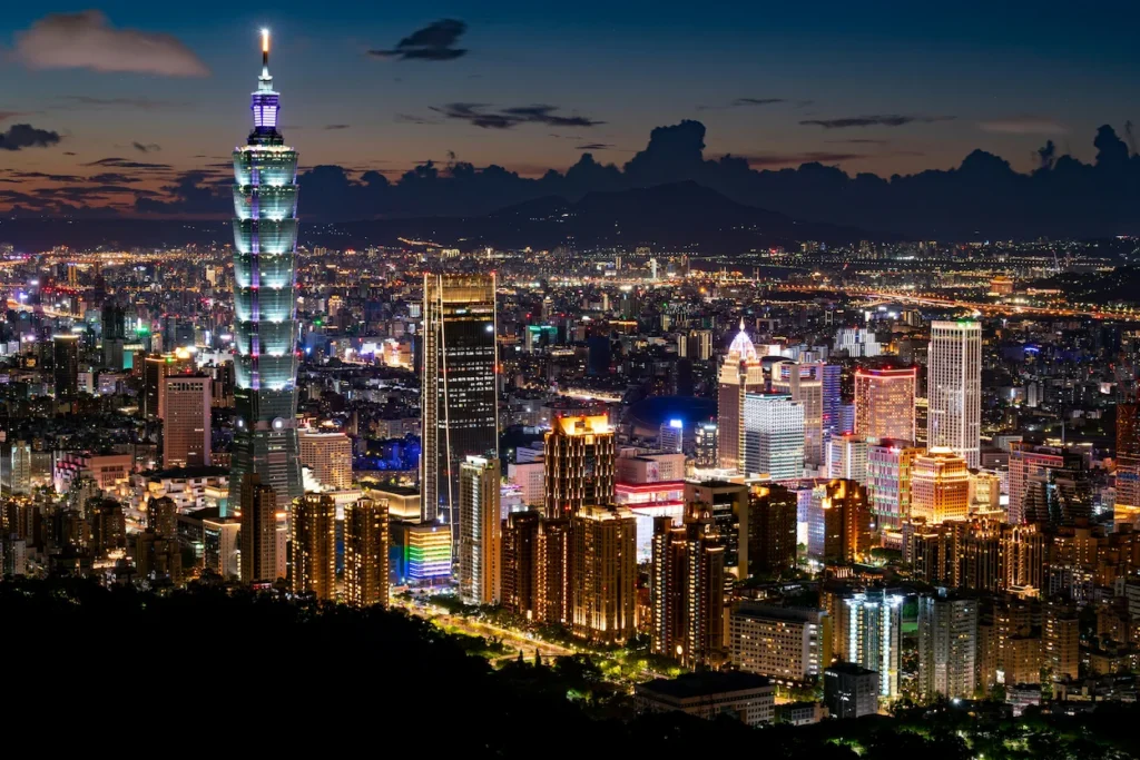 Taipei 101 skyscraper towering over the illuminated city skyline at night in Taipei