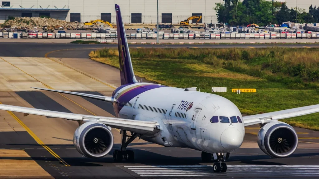 Thai Airways Boeing 787 passenger airplane taxiing down an airport runway