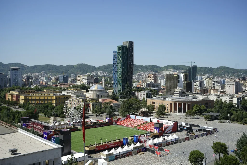 Outdoor football fan zone on Skanderbeg Square with skyscrapers behind in Tirana
