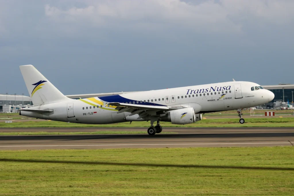 TransNusa Airbus A320 commercial airplane with distinctive blue and yellow tail graphics