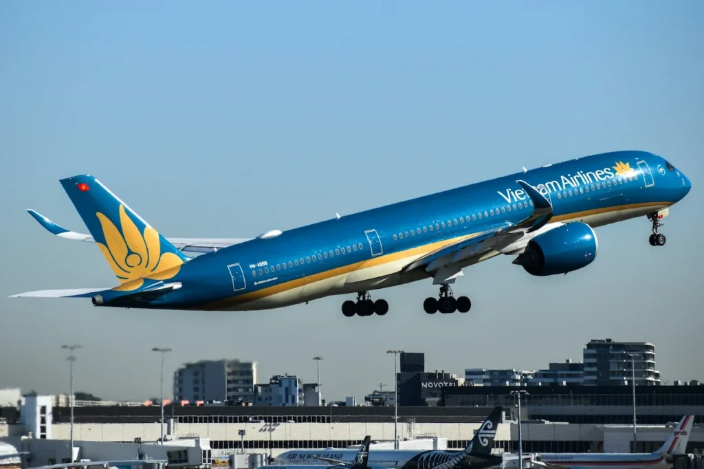 Vietnam Airlines Airbus A350-900 taking off above an airport terminal