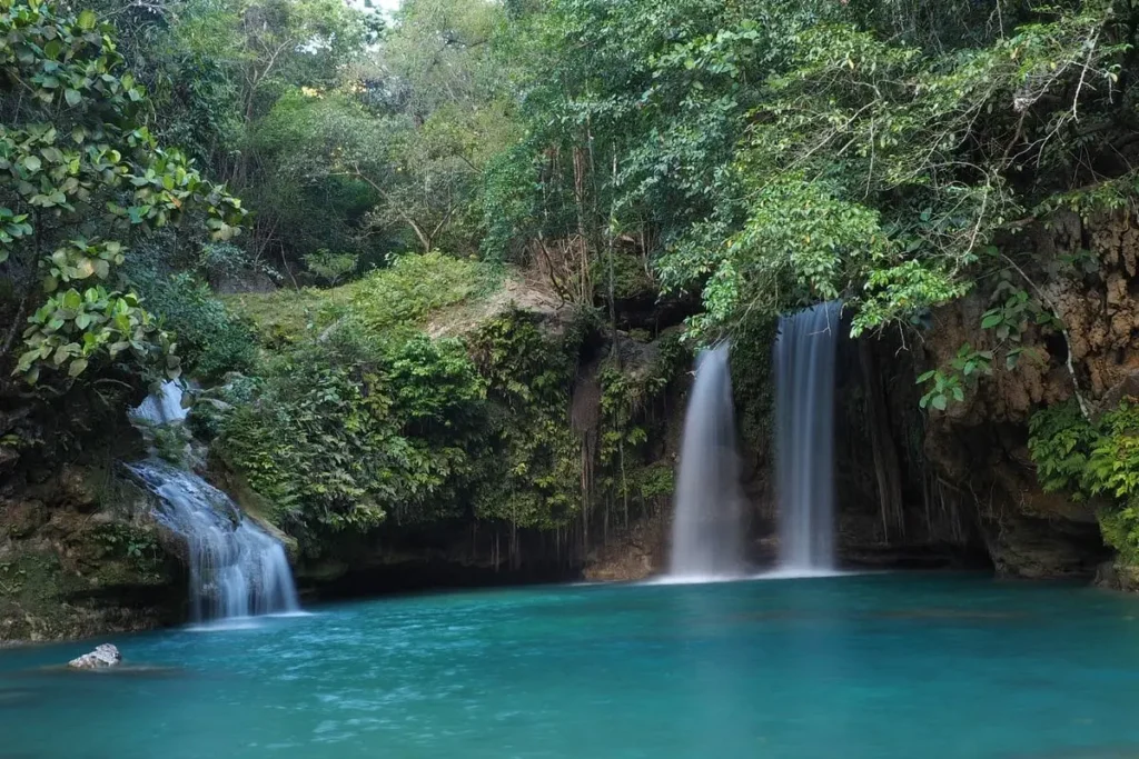 Twin waterfalls flowing into a turquoise pool at Kawasan Falls.