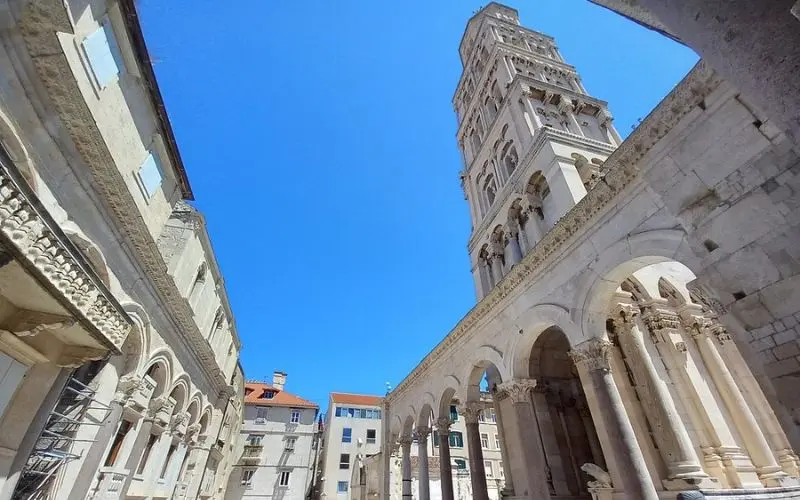 View of Diocletian's Palace with its tall bell tower and stone arches in Split.